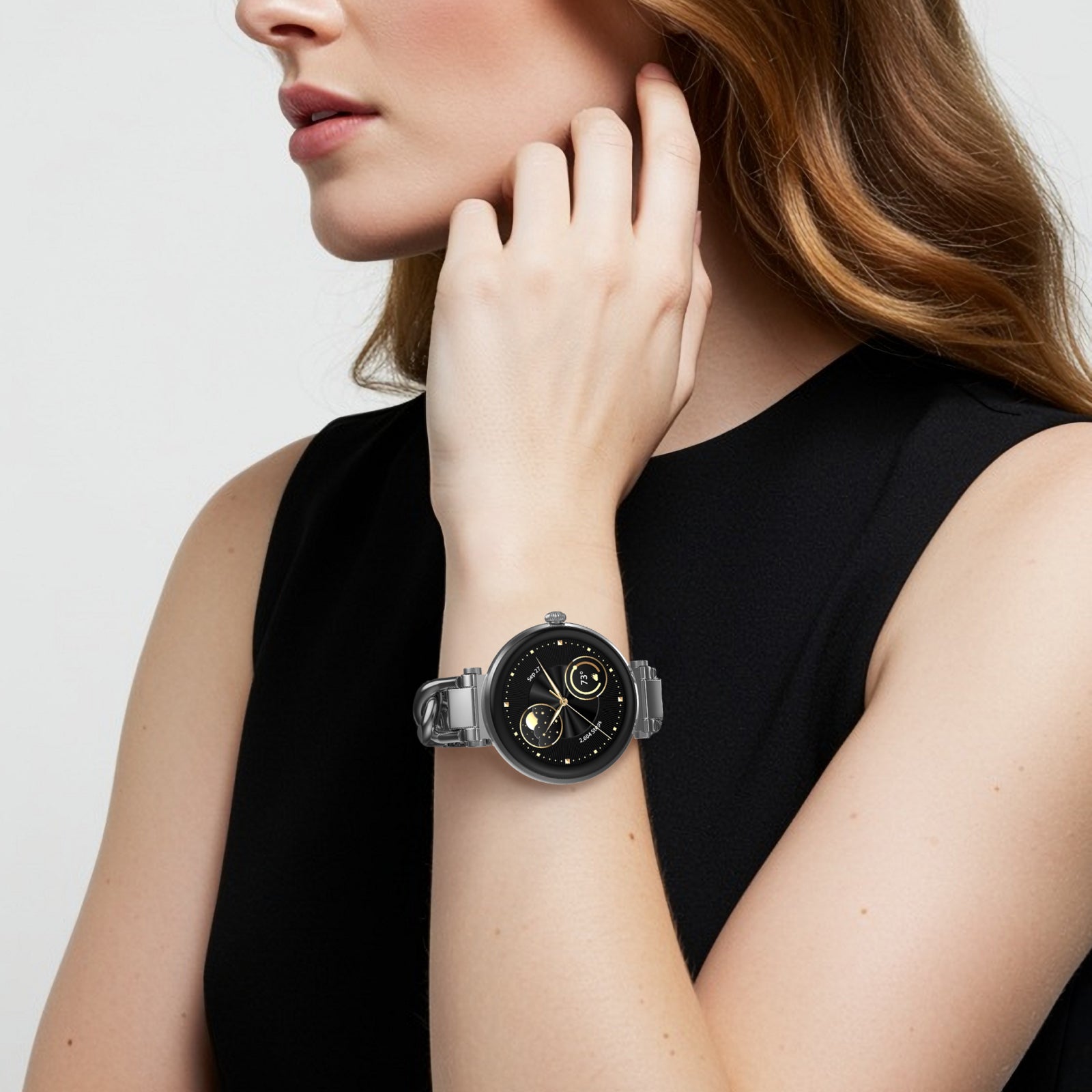 Woman wearing a black smartwatch on a plain background